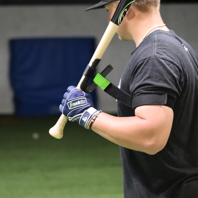 adult male holding a bat with swingrail swing trainer