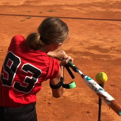 youth female player swinging a bat